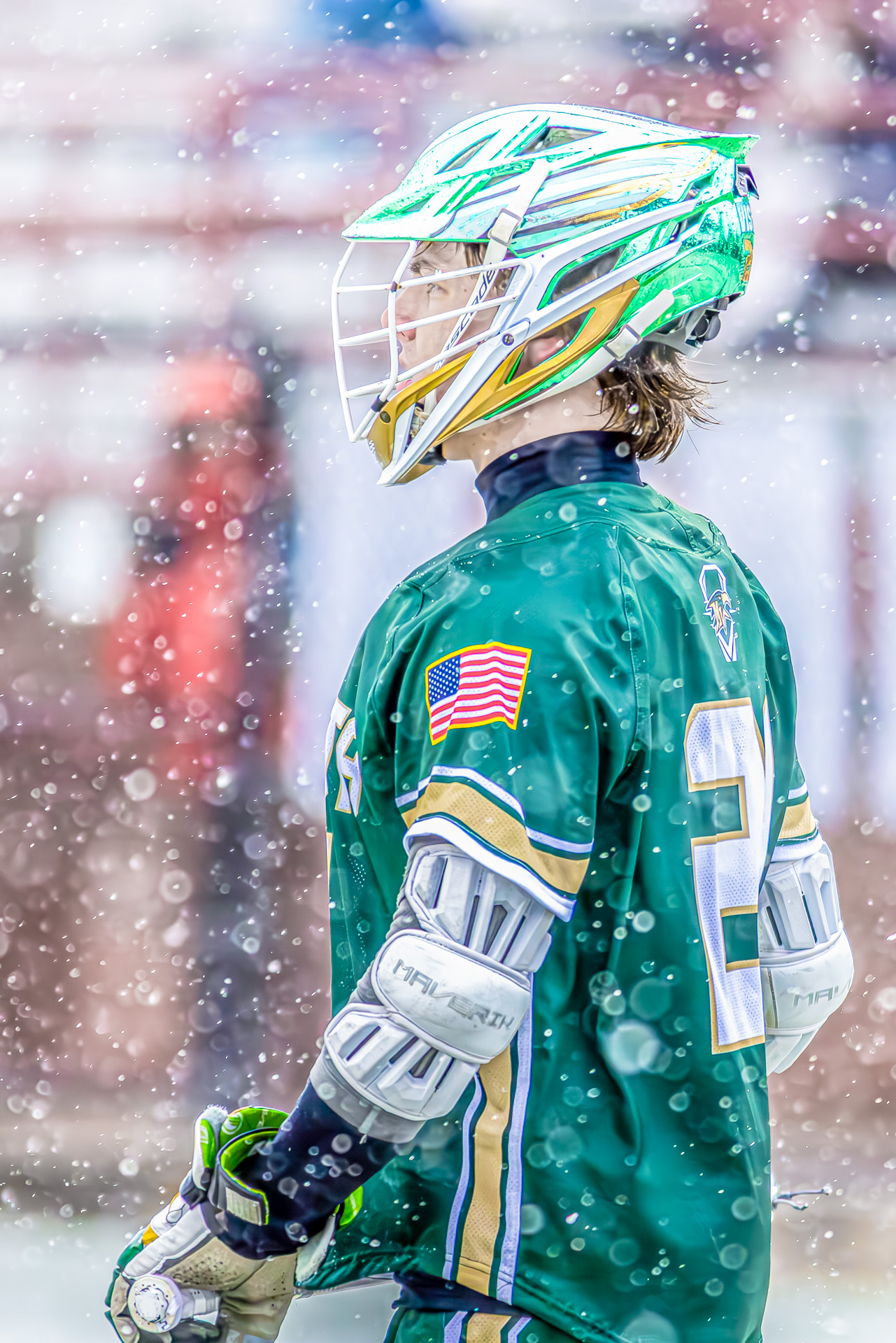Mountain Vista Lacrosse team playing in the snow, showcasing dynamic action and vibrant metallic green helmets.