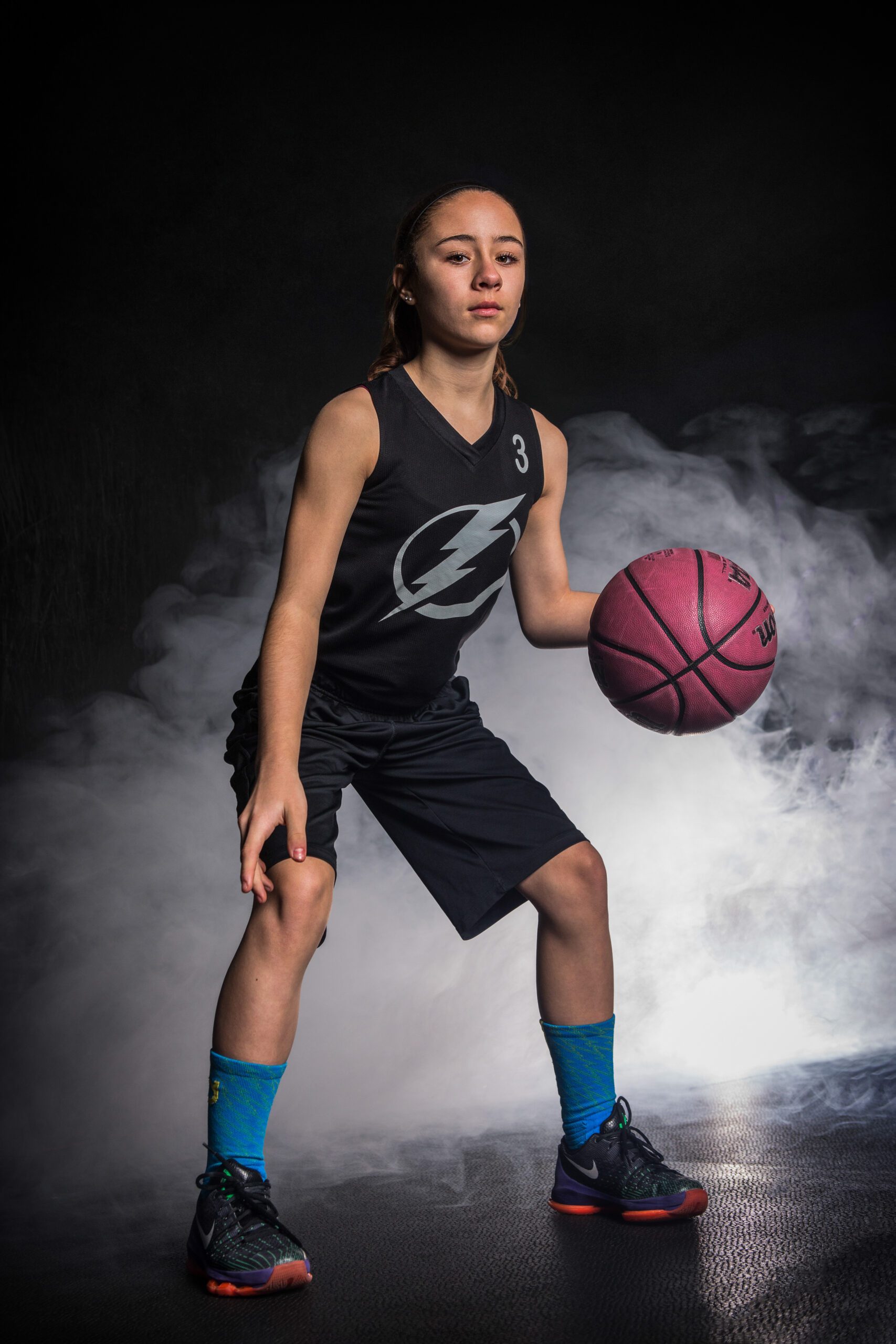 Girl Basketball Player With Ball in Smoky Backdrop